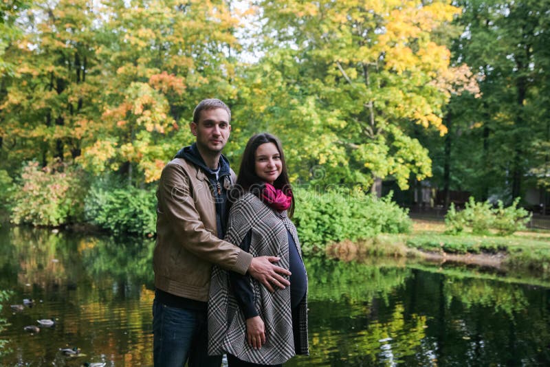 Young pregnant couple in a fall park stock photo