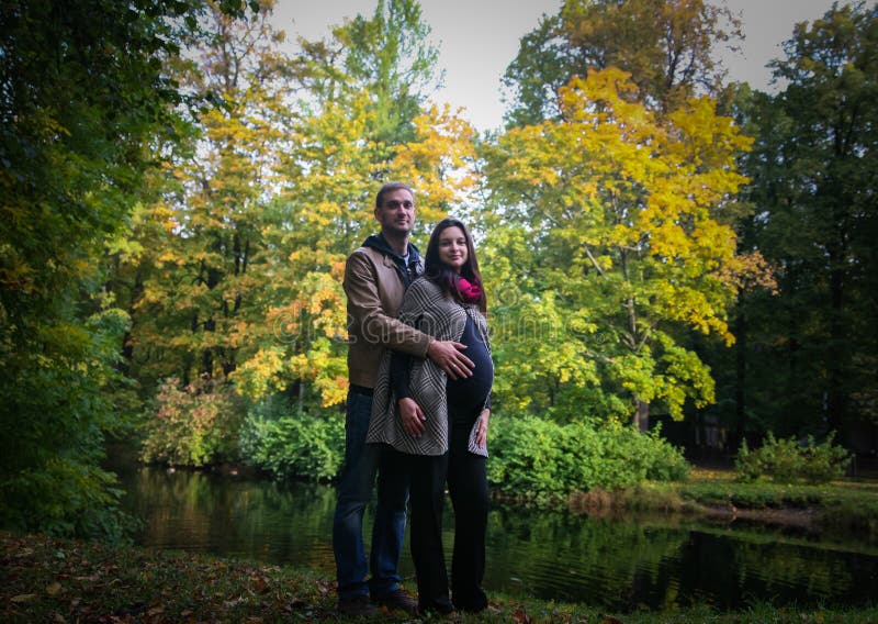 Young pregnant couple in a park in the fall stock images