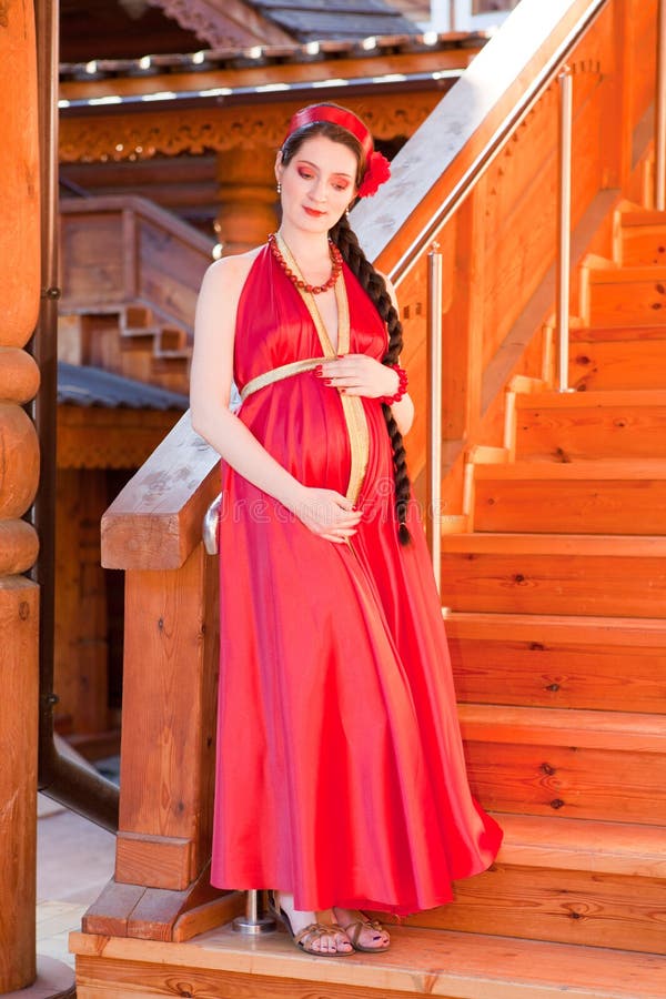 A young pregnant girl standing on the stairs