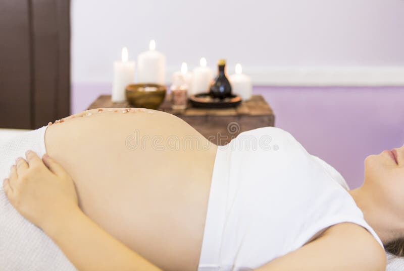 Young pregnant woman have massage treatment at spa