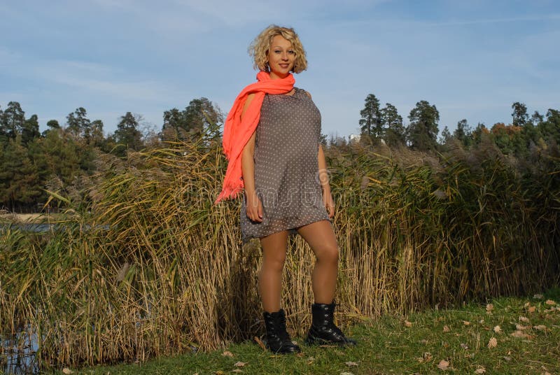 Young pregnant woman in orange scarf standing in autumn park. royalty free stock photo Young pregnant woman in orange scarf standing in autumn park. royalty free stock photo