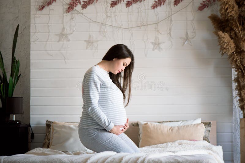 Young Pregnant Woman Sitting on a Bed Stock Photo Image of abdomen