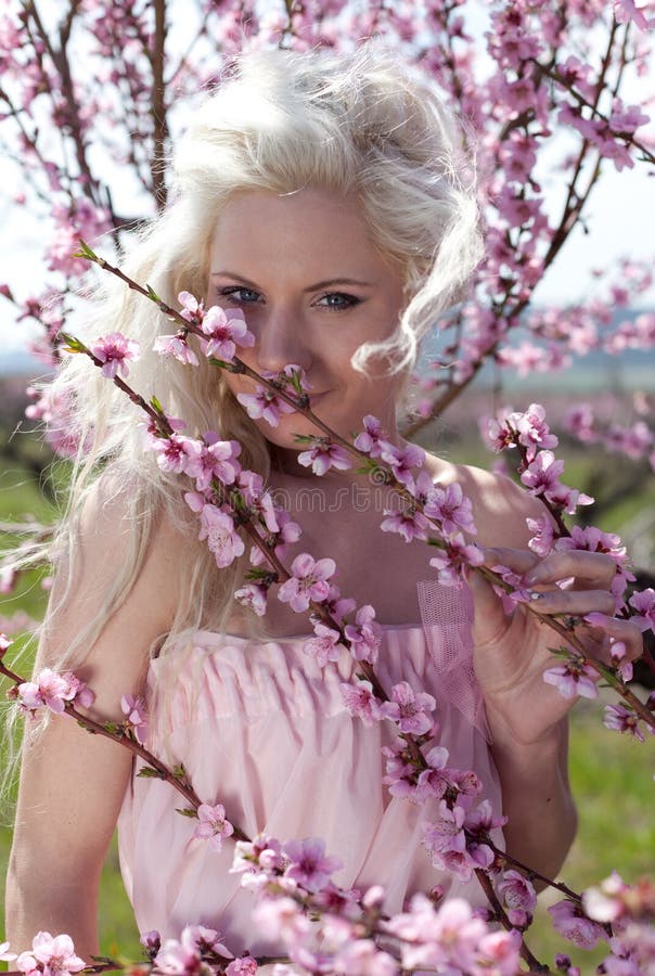 Young pretty blond woman in blooming garden