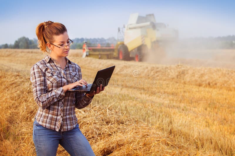 Young pretty farmer girl in glasses in wheat field