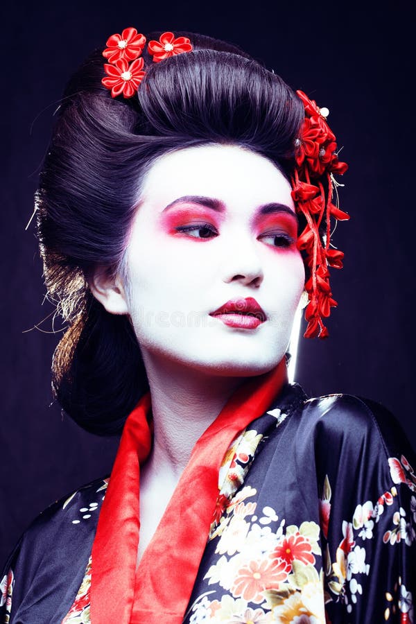 young pretty geisha in kimono with sakura and decoration on blac