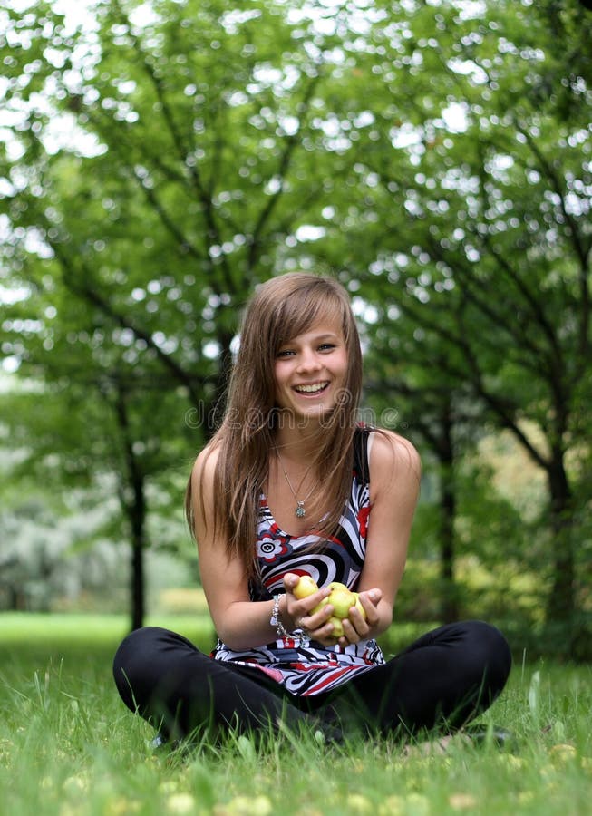 Young pretty girl with the apples on the grass