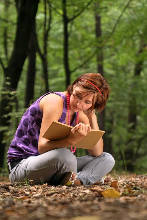 Young pretty girl reading a book.