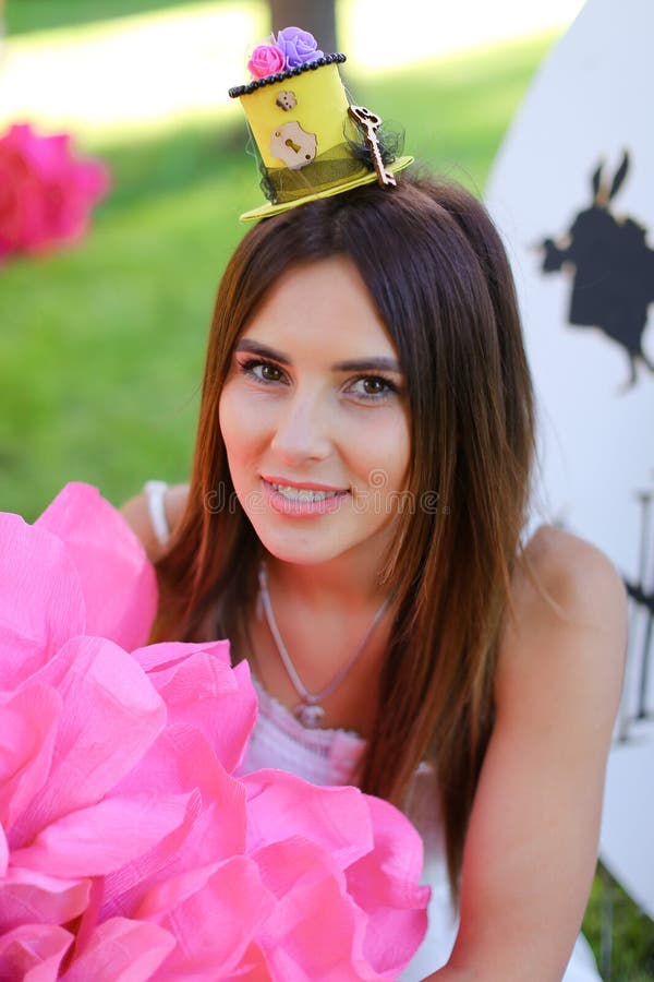 Young pretty girl sitting at decorated place for children near pink flower. stock photography