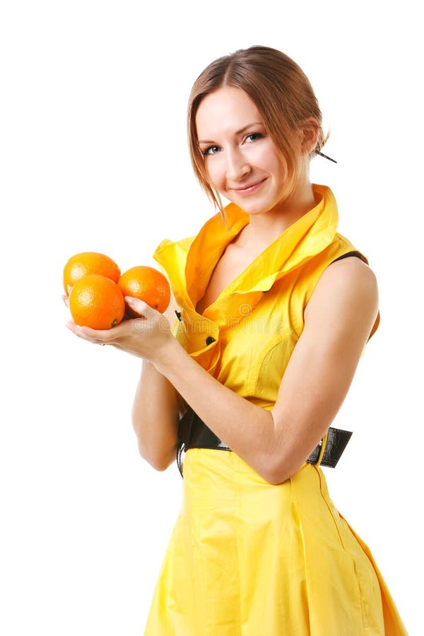 Young pretty girl in yellow dress with oranges