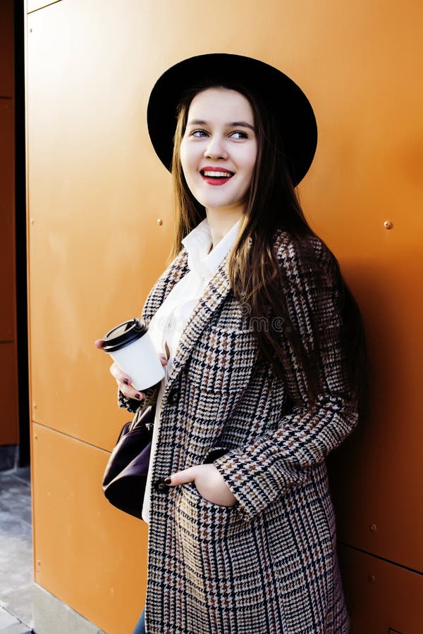 Young pretty hipster girl student with coffee cup posing adorable smiling, lifestyle people concept outdoor