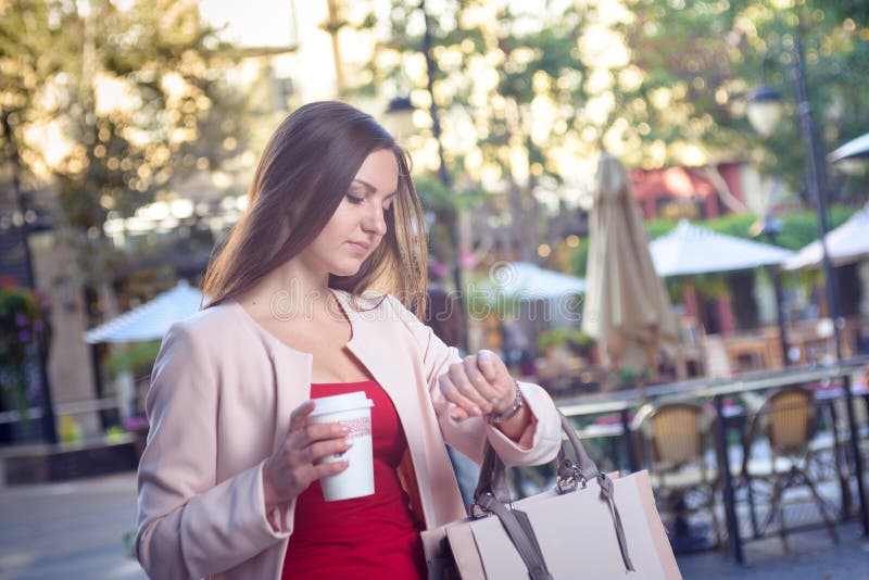 Young pretty woman checking time hurrying down city street stock photos Young pretty woman checking time hurrying down city street stock photos