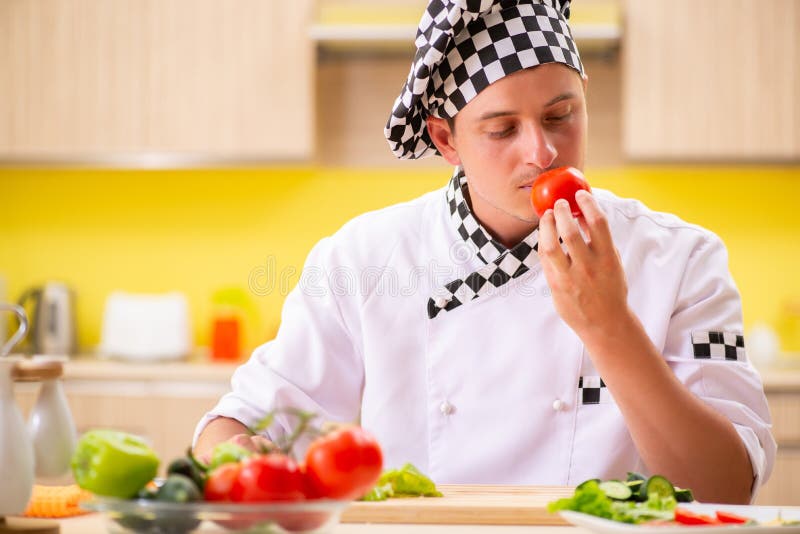 The young professional cook preparing salad at kitchen stock image The young professional cook preparing salad at kitchen stock image