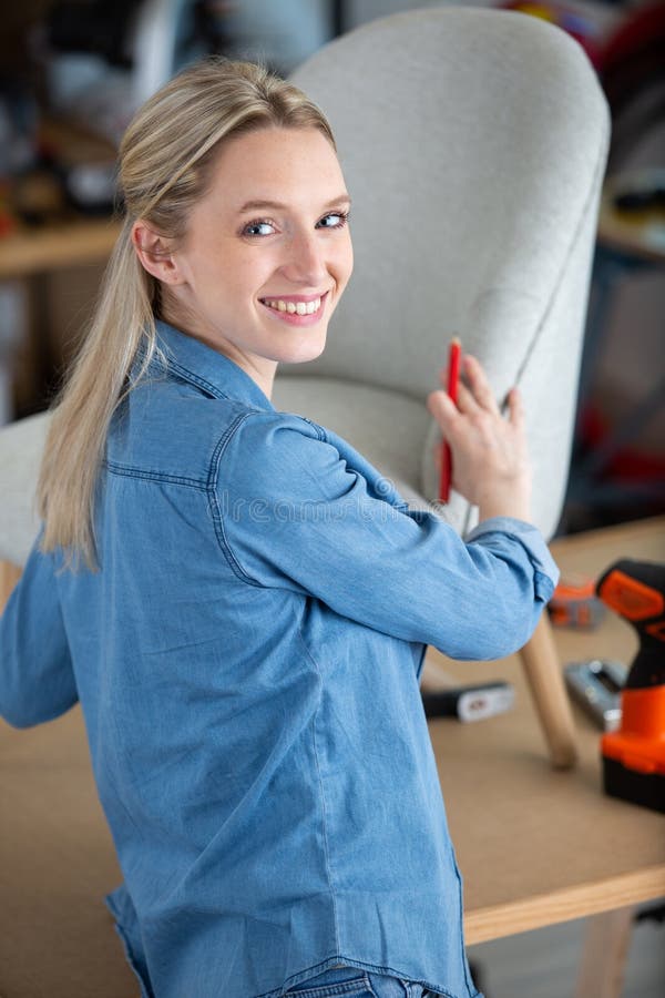 Young Professional Decorator during Upholstery Armchair Stock Photo