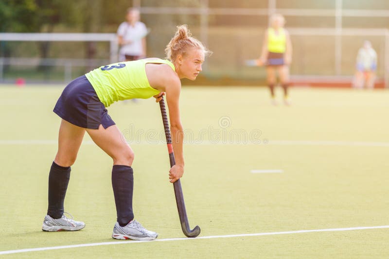 Young professional hockey player with stick on the field stock photos