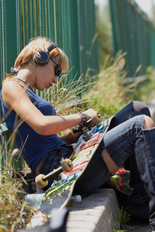 Young punk girl skater in headphones