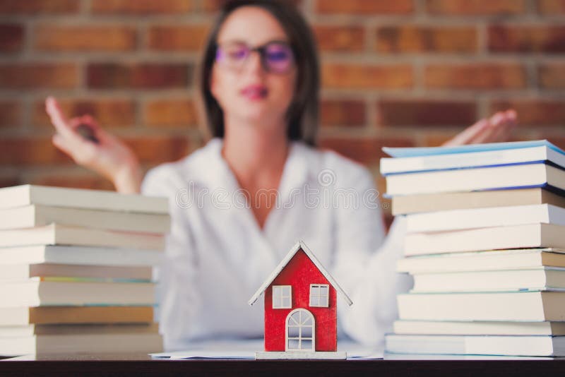 Realtor with books and house