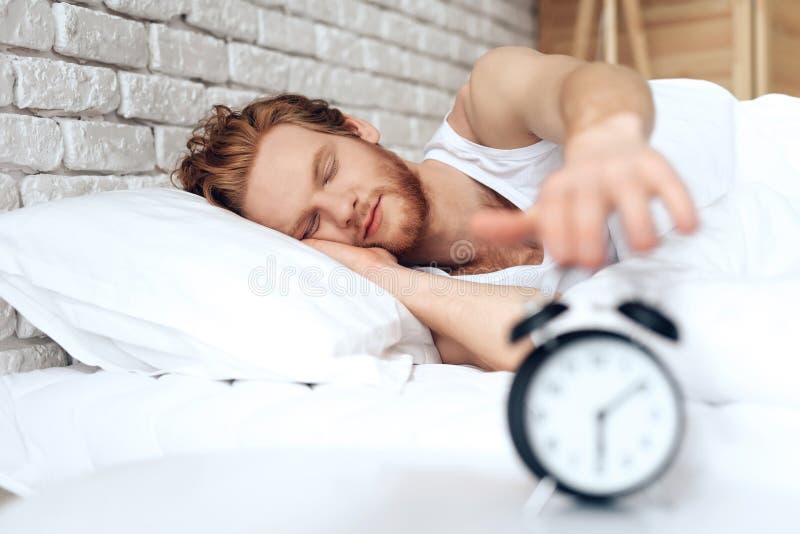 Young red haired man reaches out to turn off royalty free stock image Young red haired man reaches out to turn off royalty free stock image