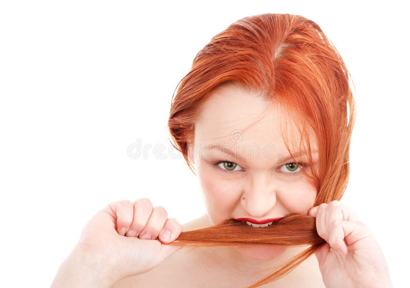 Young redhead woman biting her hair