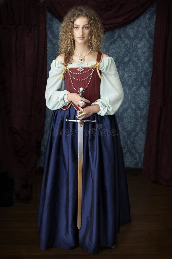 A young Renaissance woman wearing a blue silk skirt and a red brocade corset and holding a large sword. A young Renaissance woman wearing a blue silk skirt and a red brocade corset and holding a large sword