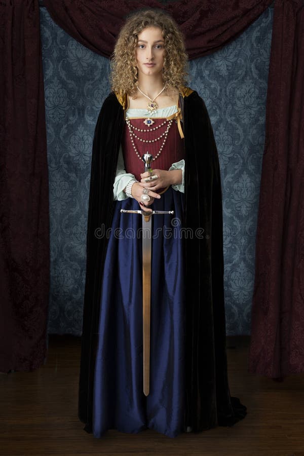 A young Renaissance woman wearing a velvet cloak, a blue silk skirt and a red brocade corset and holding a large sword. A young Renaissance woman wearing a velvet cloak, a blue silk skirt and a red brocade corset and holding a large sword