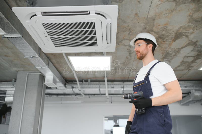 Young Repairman Repairing Ceiling Air Conditioning Unit Stock Image