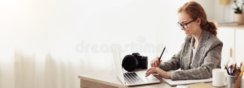 Young reporter transfering image data from camera to laptop stock photography