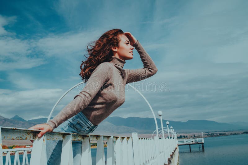 Young romantic beautiful woman posing on bridge royalty free stock images