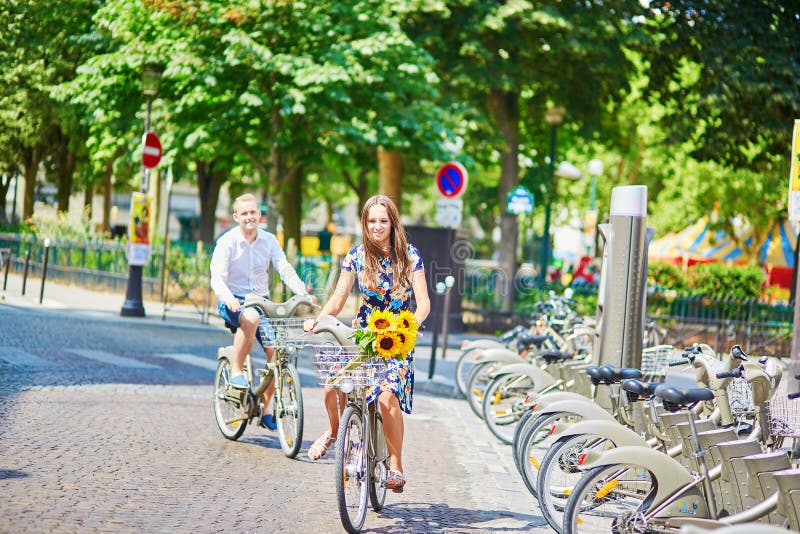 Young romantic couple using bicycles in Paris, France