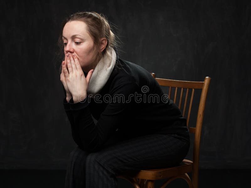 Young sad disoriented woman sitting on the chair