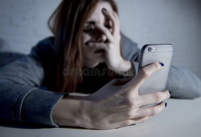 Young sad vulnerable girl using mobile phone scared and desperat
