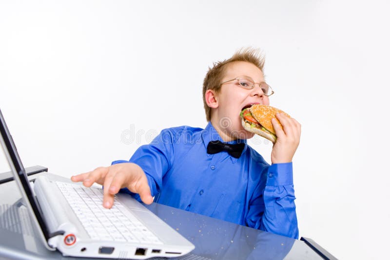 Young school boy eating hamburger