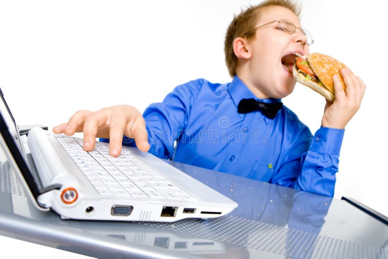 Young school boy eating hamburger