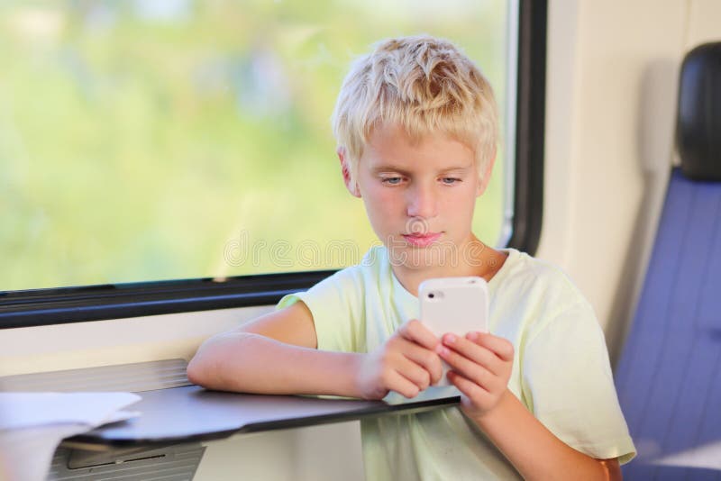 Young school boy in train with mobile phone stock photography Young school boy in train with mobile phone stock photography