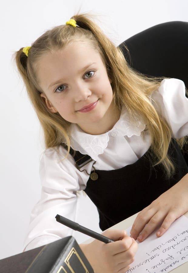 Young schoolgirl writing in a classroom