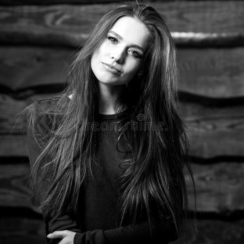 Young sensual & beauty brunette woman pose on wooden background. Black-white photo