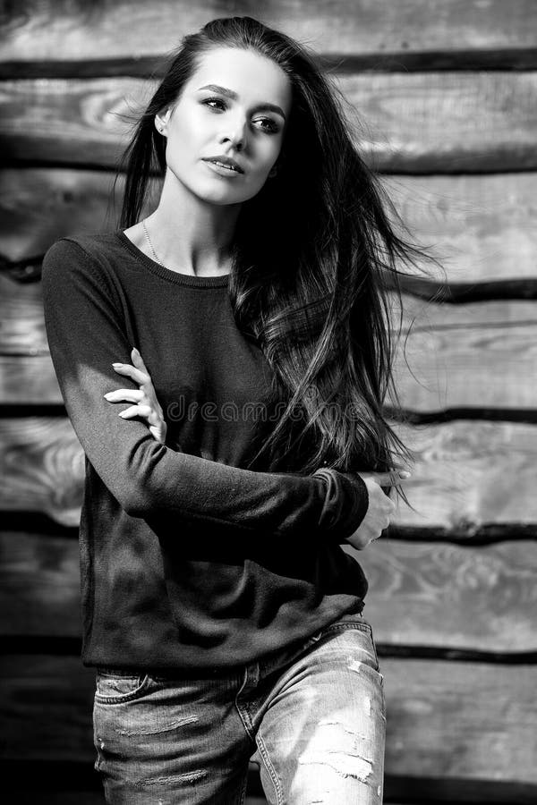 Young sensual & beauty brunette woman pose on wooden background. Black-white photo