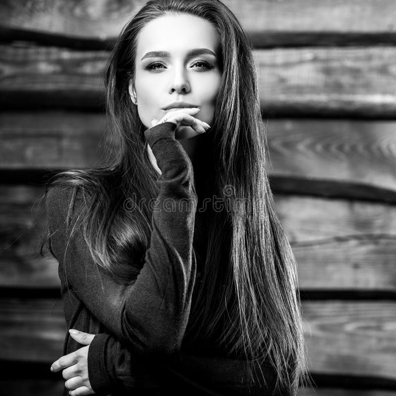 Young sensual & beauty brunette woman pose on wooden background. Black-white photo