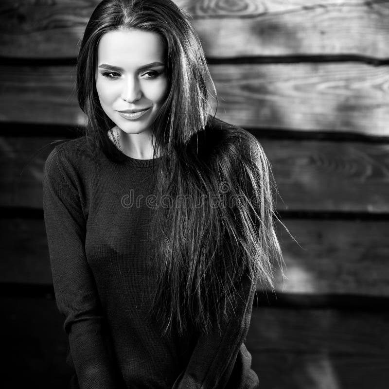 Young sensual & beauty brunette woman pose on wooden background. Black-white photo