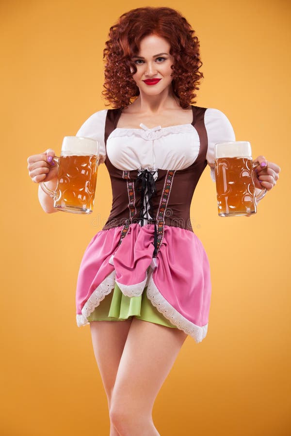 Young Oktoberfest waitress, wearing a traditional Bavarian dress, serving big beer mugs on yellow background. stock photography Young Oktoberfest waitress, wearing a traditional Bavarian dress, serving big beer mugs on yellow background. stock photography