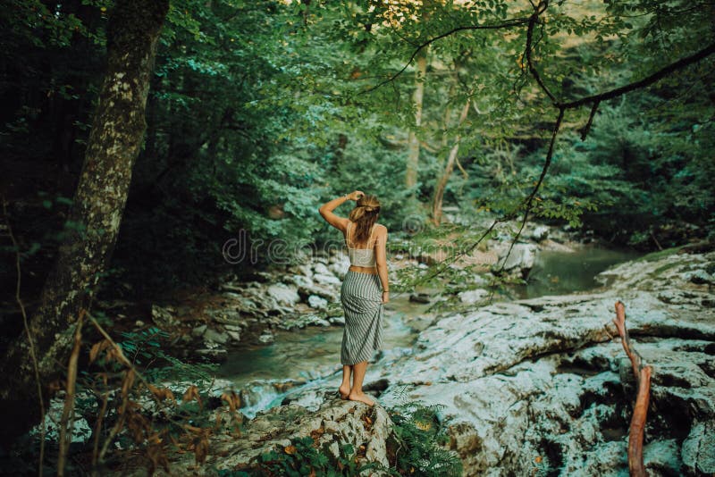 Young and sexy woman sit on rock wearing swimsuit on the beautiful waterfall in the jungle stock photos Young and sexy woman sit on rock wearing swimsuit on the beautiful waterfall in the jungle stock photos
