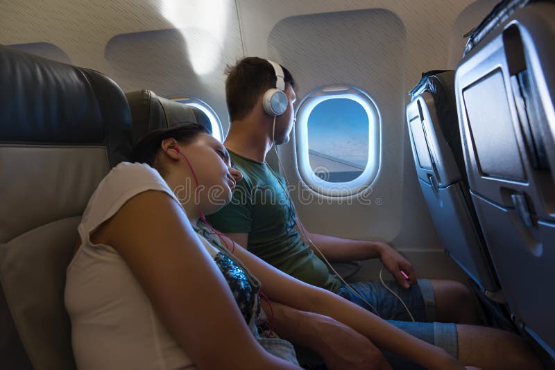 Young sleeping woman lying on the male shoulder while traveling