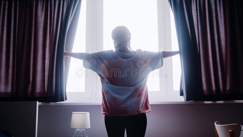 Young sleepy lonely woman looking through the window. High quality photo