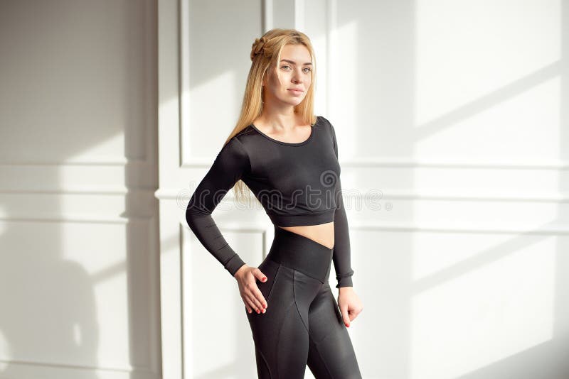 Slim motivated brunette woman dressed in cropped top and leggings