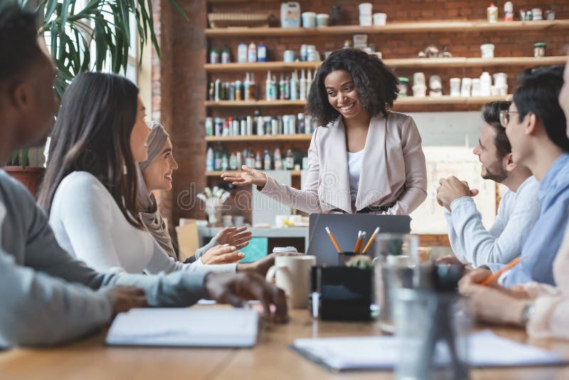 Young afro woman manager leading morning briefing in office stock images Young afro woman manager leading morning briefing in office stock images