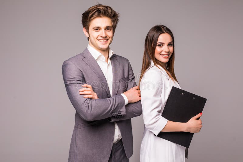 Young smiling business woman and business man isolated on gray background