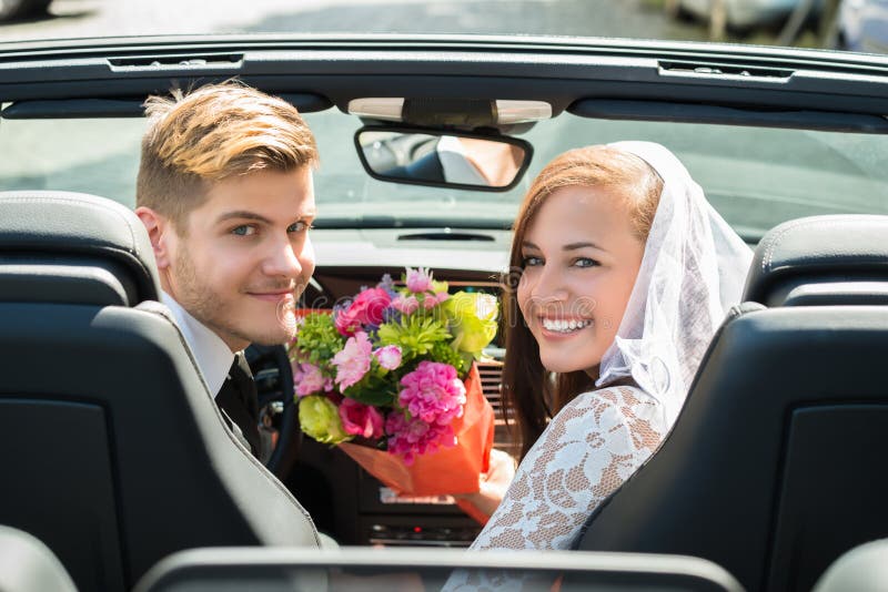 Just Married Couple With Bouquet In The Car