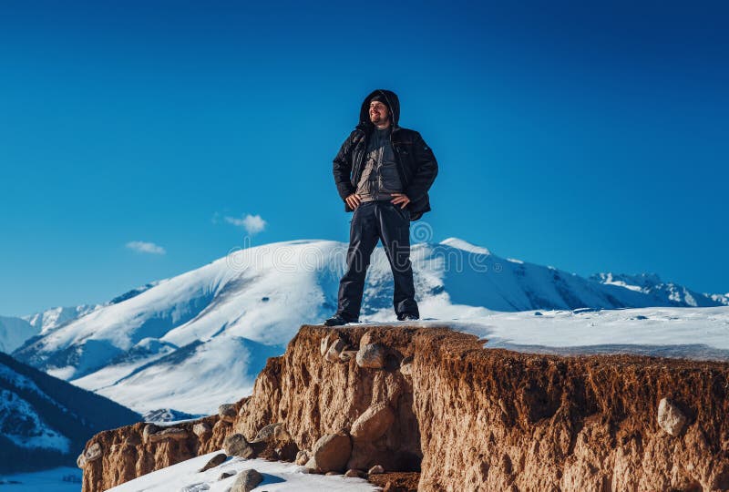 Smiling man tourist standing on mountain at winter season royalty free stock photos