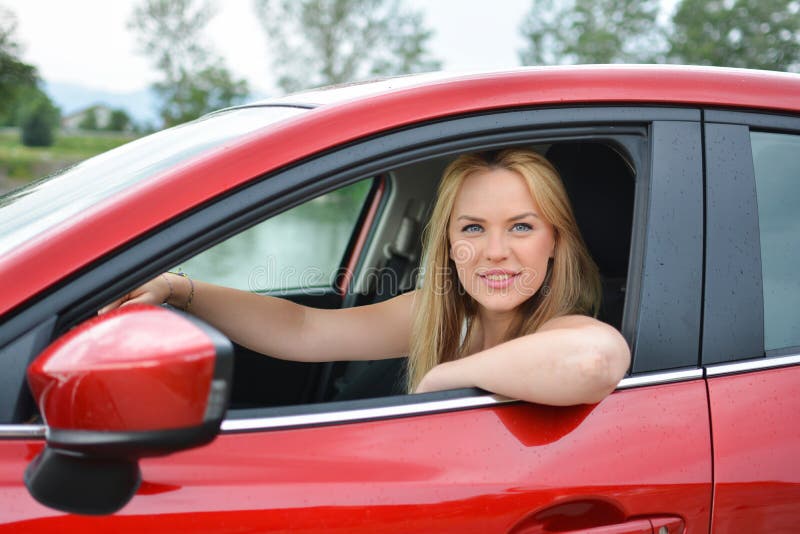Young Smiling And Satisfied Blonde Girl In Red Car Stock Image Image