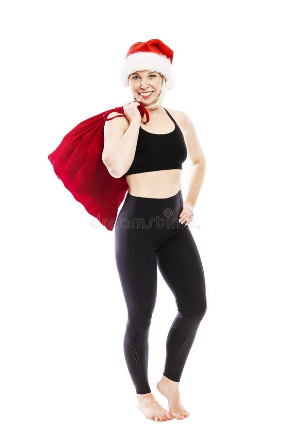 Young smiling woman in a black tracksuit in a Santa Claus hat and a red bag with gifts. Full height. Isolated over white stock photos Young smiling woman in a black tracksuit in a Santa Claus hat and a red bag with gifts. Full height. Isolated over white stock photos