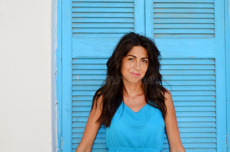 Young smiling woman with blue dress on a wooden blue shutter stock photos Young smiling woman with blue dress on a wooden blue shutter stock photos